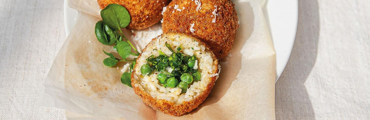 Arancini, boule de riz frite avec chapelure, fourrée aux petits pois verts